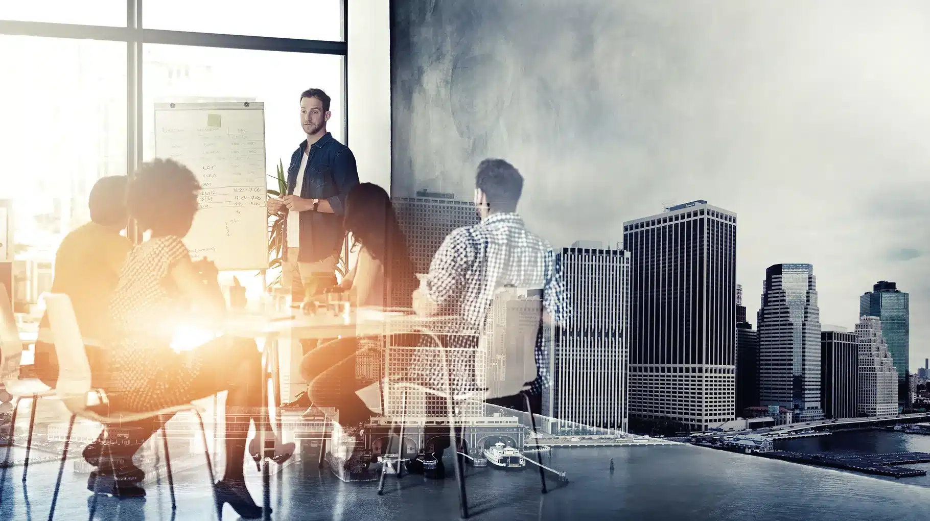 Business professionals collaborating in an office with a city skyline visible through the windows in the background.