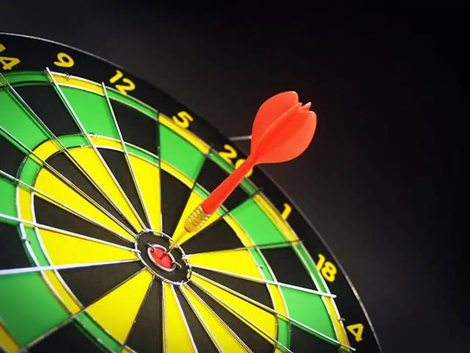 A dart strikes the bullseye on a dartboard, showcasing a perfect shot in a game of darts.