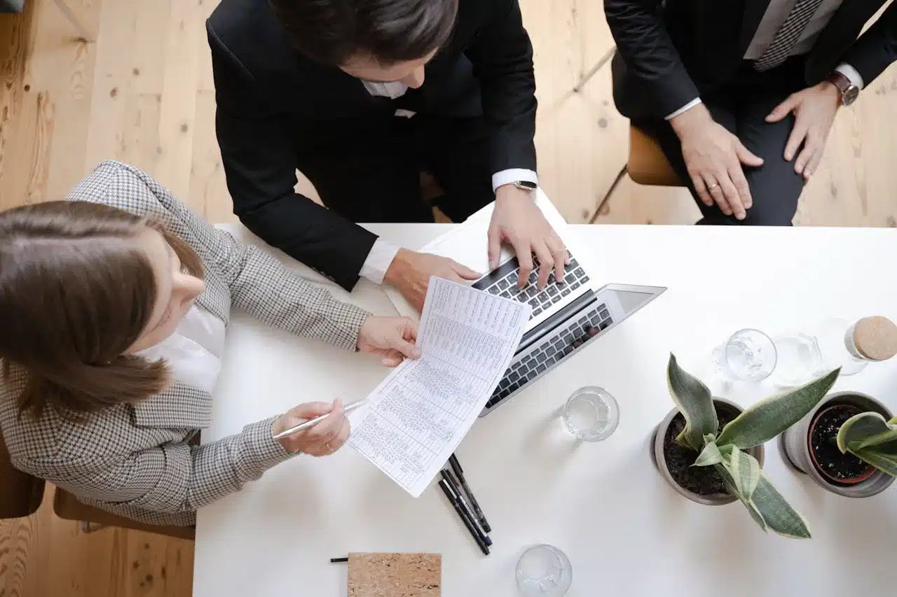 A woman analyzes data on a computer, focusing on graphs and charts displayed on the screen.