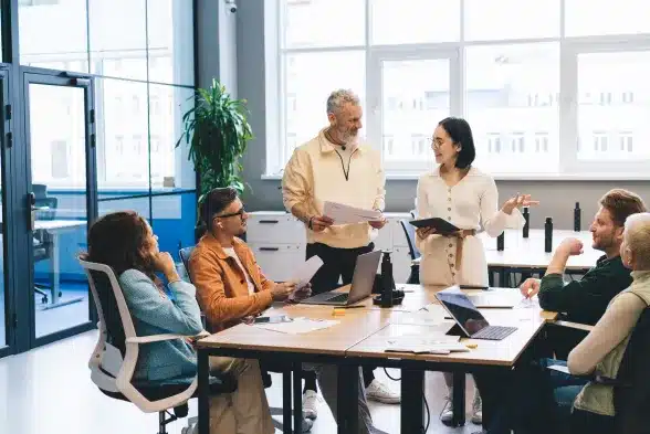 A diverse group of professionals engaged in a collaborative discussion during an office meeting.