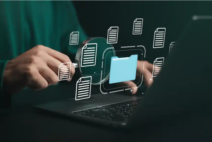Man working on a laptop with folder icons displayed on the screen, focused on his task.
