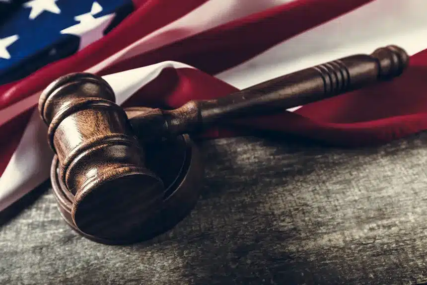 Judge's gavel resting on an American flag, symbolizing justice and patriotism in a legal context.