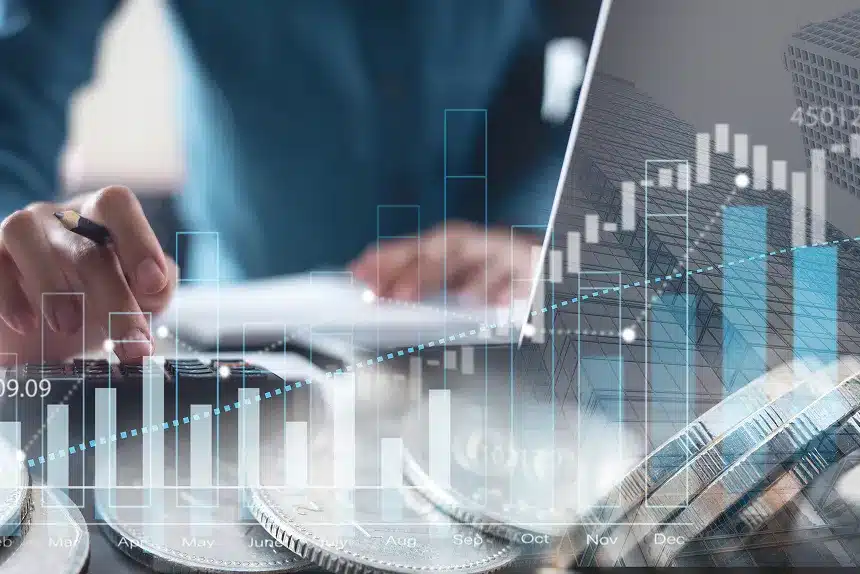 Businessman working on a laptop with coins scattered on the table, symbolizing finance and investment.