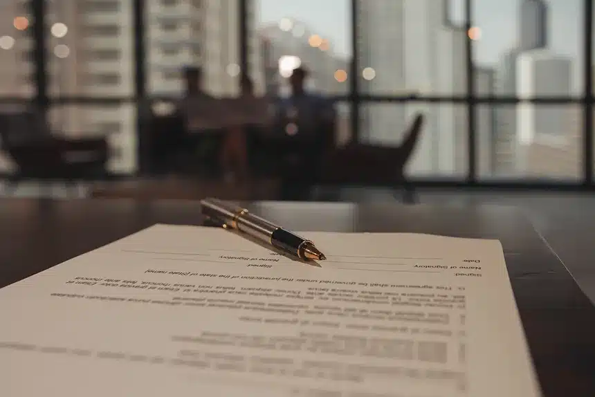A pen rests on a paper document, indicating a task or note-taking activity.
