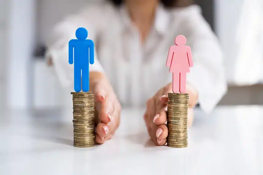 A person holds a stack of coins topped with a blue man and a pink woman figurine, symbolizing financial partnership.