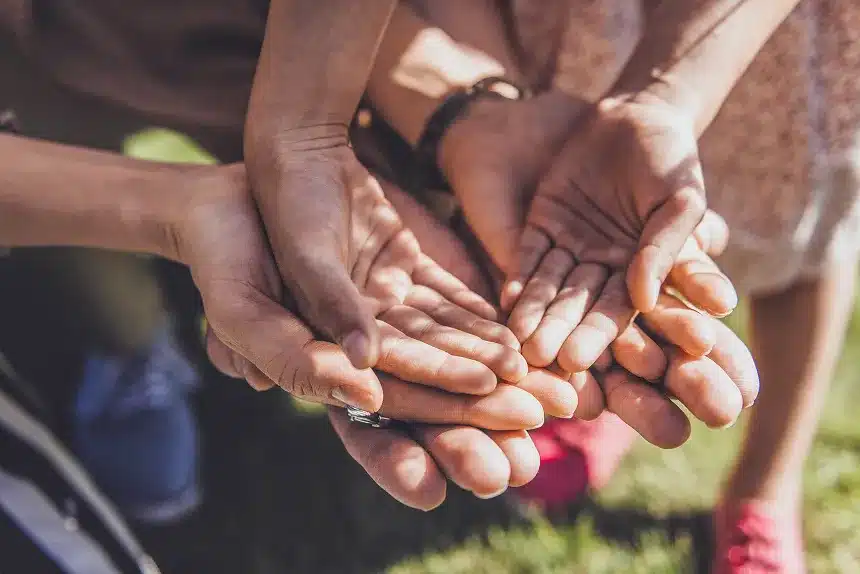 A diverse group of people standing in a circle, holding hands, symbolizing unity and togetherness.