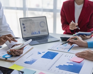 A group of business professionals collaborating on a strategic business plan in a modern office setting.