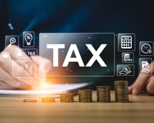 A desk displaying a tax concept with scattered coins and banknotes, symbolizing financial planning and management.