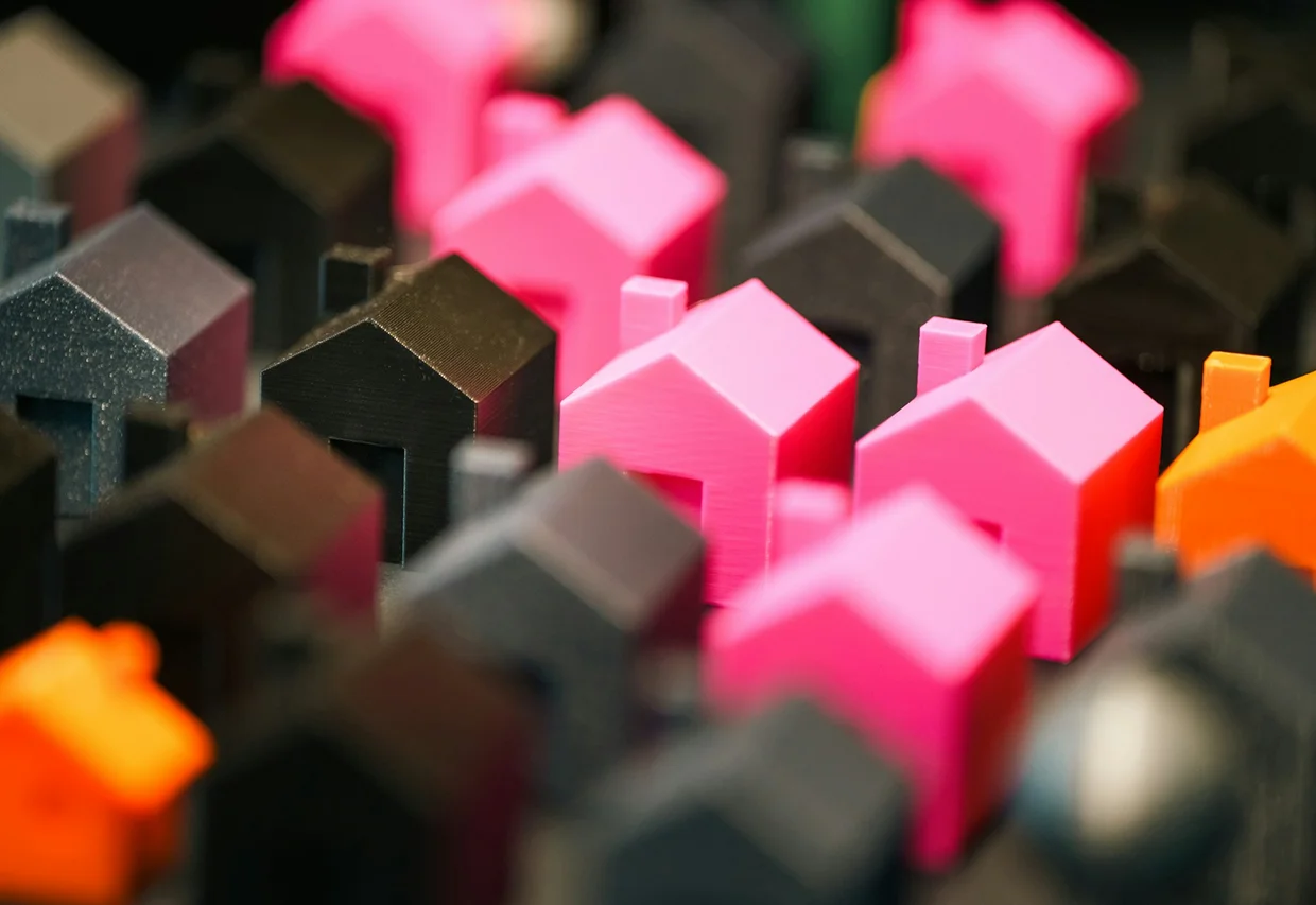 Colorful toy houses arranged closely together, showcasing a variety of shapes and vibrant hues.